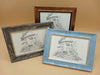 Three framed images of a fairy house with a mushroom shaped roof.