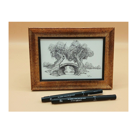 Framed black and white landscape drawing with two black markers on a beige background
