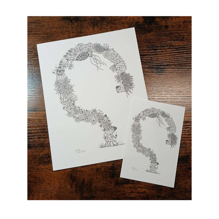 Two prints of stylized tree design with intricate details on a wooden surface